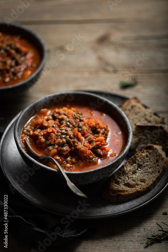 assiette de soupe de lentilles et tomates fait maison aux herbes et épices