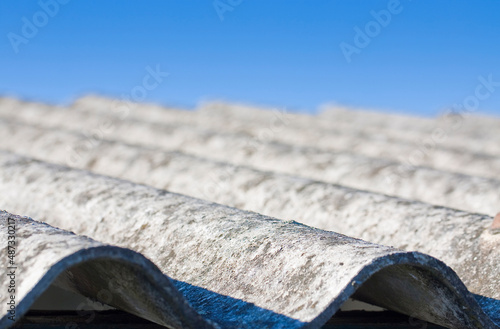 Old aged dangerous roof made of corrugated asbestos panels - one of the most dangerous materials in buildings and construction industry so-called hidden killer photo