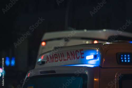 Close-up of an ambulance with lights at night, copy space
