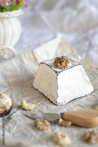 Various types of cheese with white mold on packaging paper.