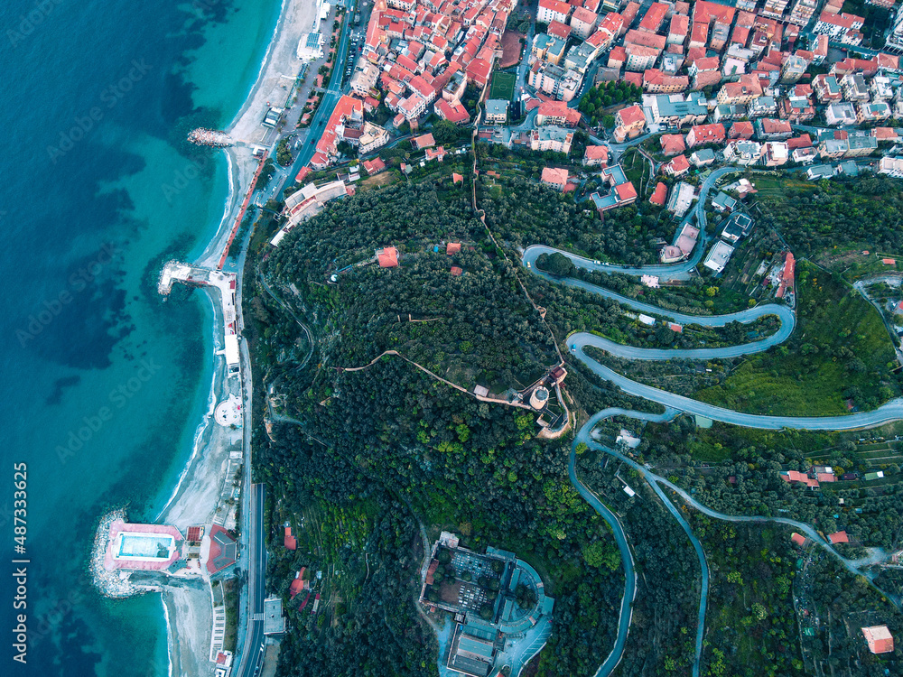 Naklejka premium Aerial view of Noli, a beautiful small village in Liguria, north Italy. Drone photography of the Ligurian coast, province of Savona, near Spotorno and Bergeggi. Birds eye of Capo Noli and Monte Ursino