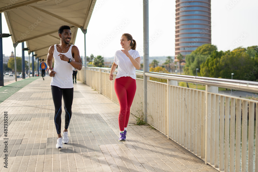 Obraz premium two interracial people running on the street