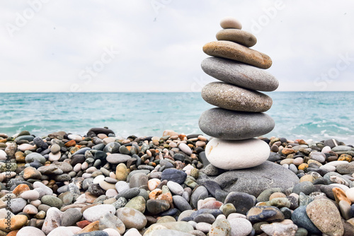 Pyramid stones balanced on the beach. The object is in focus, the background is blurred.