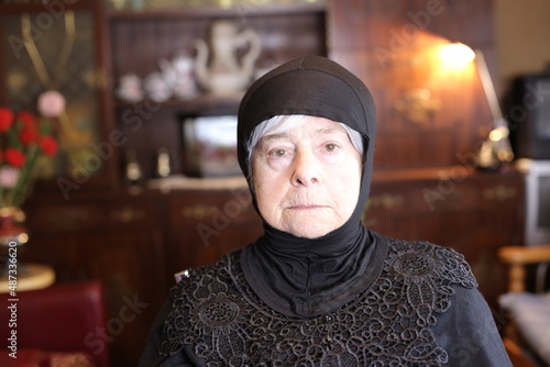 Senior religious lady wearing traditional head scarf