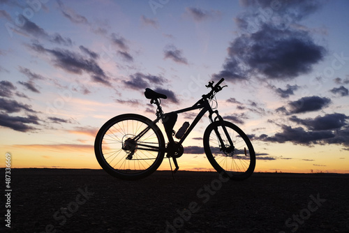 Fototapeta Naklejka Na Ścianę i Meble -  Bicycle silhouette at sunset against the evening sky