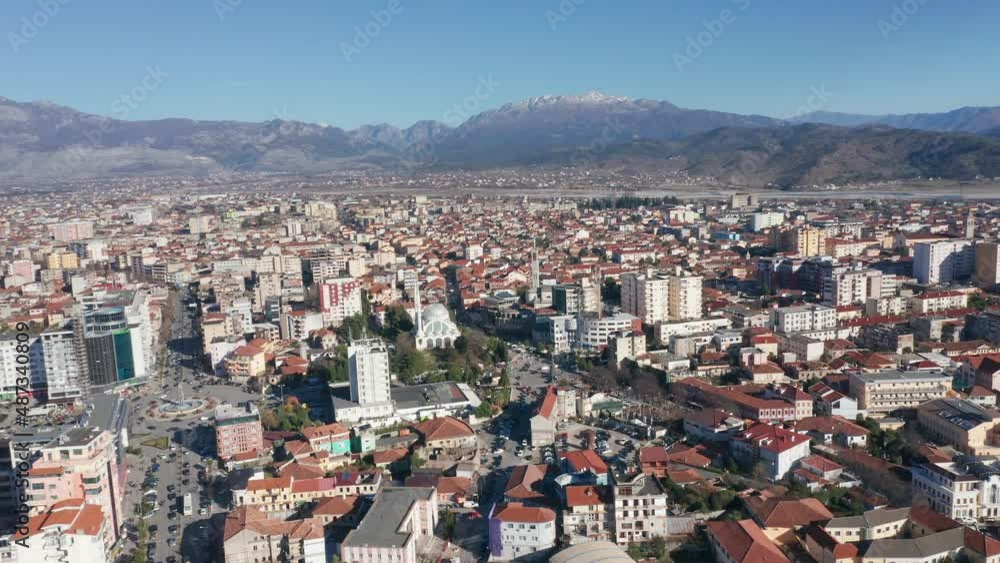 Shkoder Albania cityscape - skyline of a city, with buildings and houses, surrounded by high hills and mountains. Aerial drone view of Shkodra (Skadar) on a sunny day with clear blue sky. Shkoder Albania cityscape - skyline of a city, with buildings and houses, surrounded by high hills and mountains. Aerial drone view of Shkodra (Skadar) on a sunny day with clear blue sky.