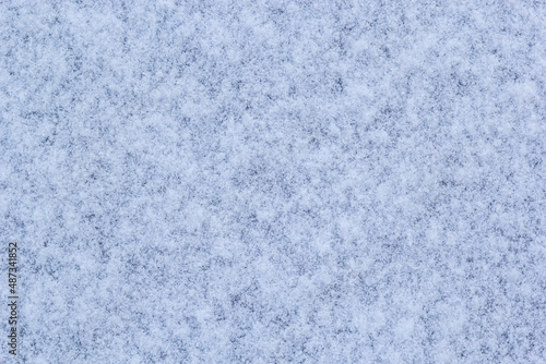 Beautiful winter background with snowy ground. Natural snow texture. Wind sculpted patterns on snow surface