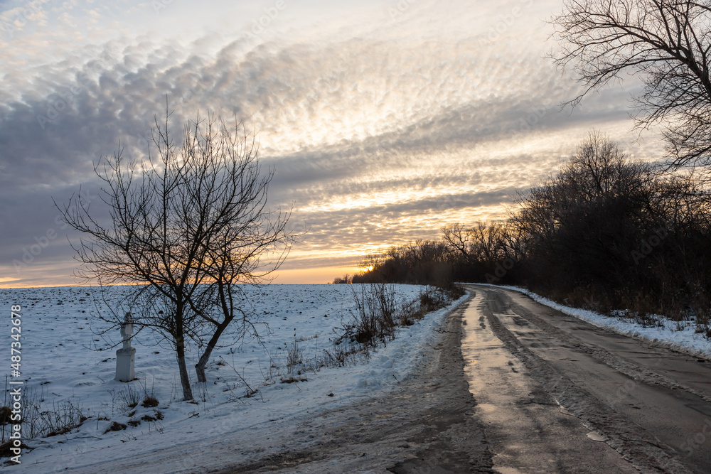 Winter road outside the city, cleared of snow in the countryside. Large snowdrifts on the side of the road Winter road outside the city, cleared of snow in the countryside. Large snowdrifts on the side of the road