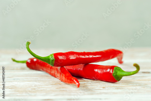 Peppers on a white background. Vegetables on a white wooden table. Chili peppers on an old shabby board. Copy space and free space for text near food.