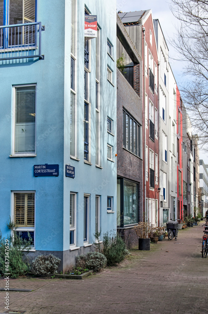 Amsterdam, The Netherlands, Febrary 11, 2022: street facade in IJbrug neighbourhood with recently built houses all having different facade materials Amsterdam, The Netherlands, Febrary 11, 2022: street facade in IJbrug neighbourhood with recently built houses all having different facade materials