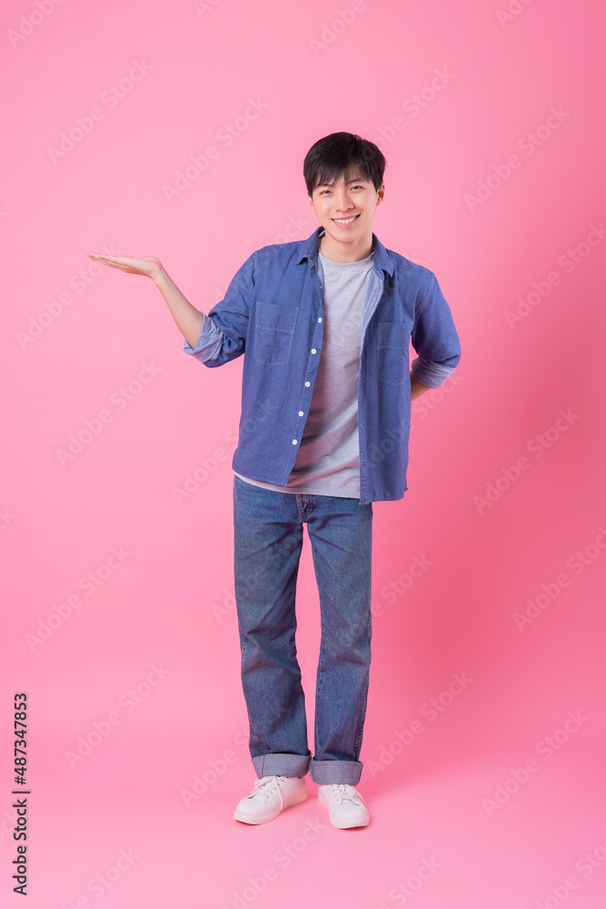 Young Asian man posing on pink background Young Asian man posing on pink background