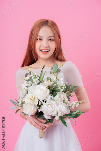Young Asian bride posing on pink background