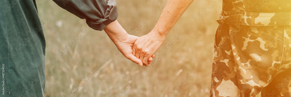 happy senior couple holding hands. hands of man and woman hold each other. romance and love and support in elderly family. husband and wife travel together in nature. countryside life. banner. flare happy senior couple holding hands. hands of man and woman hold each other. romance and love and support in elderly family. husband and wife travel together in nature. countryside life. banner. flare