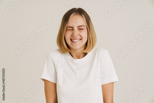 Young blonde woman in t-shirt laughing while posing on camera © Drobot Dean