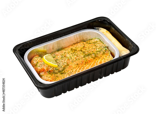 salmon ready to cook with sauce and herbs in a tray