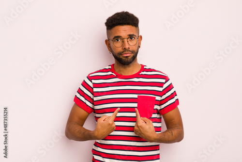 Foto young afro man pointing to self with a confused and quizzical look, shocked and