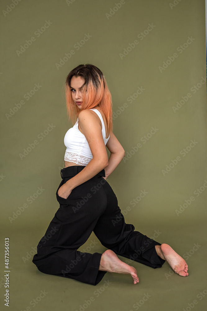 pretty curious young person stylishly dressed flaunts on a solid background. pretty curious young person stylishly dressed flaunts on a solid background.