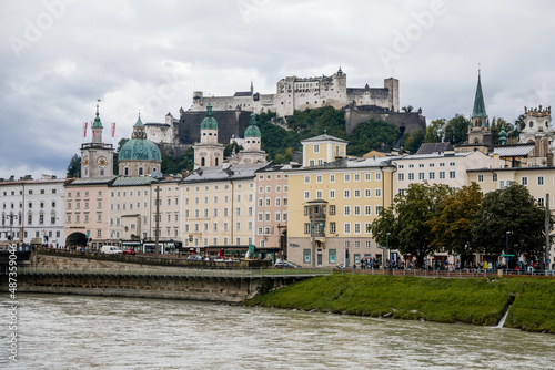 Salzburg, Austria, 28 August 2021: old medieval castle on hill, Hohensalzburg Fortress, embankment panorama of river Salzach, renaissance and baroque houses, Facade of stone building at summer day © AnnaRudnitskaya