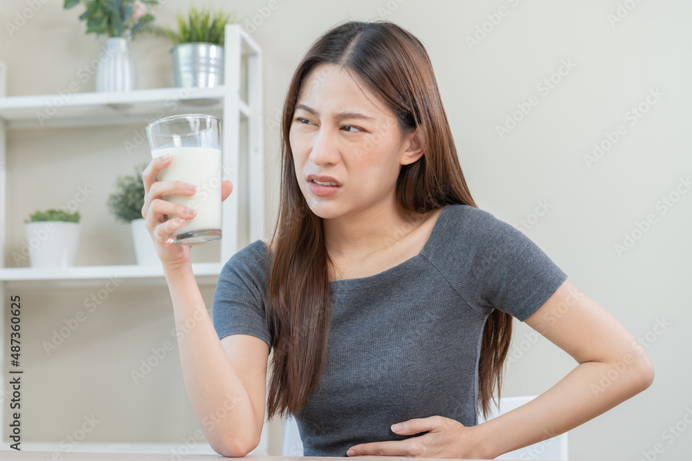 Pain, Allergy asian young woman, girl hand in belly suffer after drink glass of milk, unhappy and bad stomach ache. Lactose intolerance and dairy food , health problem concept. Pain, Allergy asian young woman, girl hand in belly suffer after drink glass of milk, unhappy and bad stomach ache. Lactose intolerance and dairy food , health problem concept.