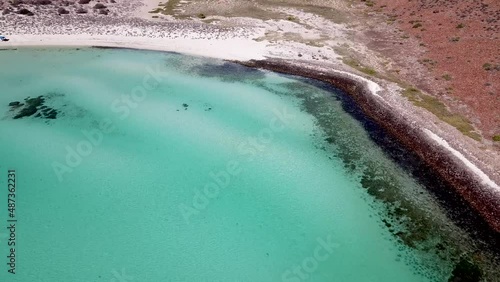 Aerial Upward Tilt Revealing Vibrant Turquoise Blue Shallow Waters of Secluded White Beach Cove in Rugged Mountains of Espiritu Santo Island BCS Mexico Drone 4k photo