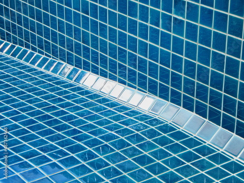 Tiled pool. The man hand while using spacer for installing tiles. construction work.Construction Pool.Technicians are tiled swimming pool.Tile for the corner of the pool. 