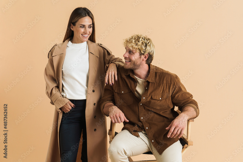 White blonde couple smiling at each other while posing together White blonde couple smiling at each other while posing together