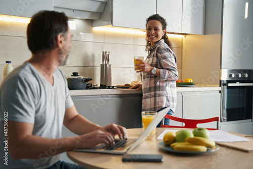 Happy woman with juice smiling at husband