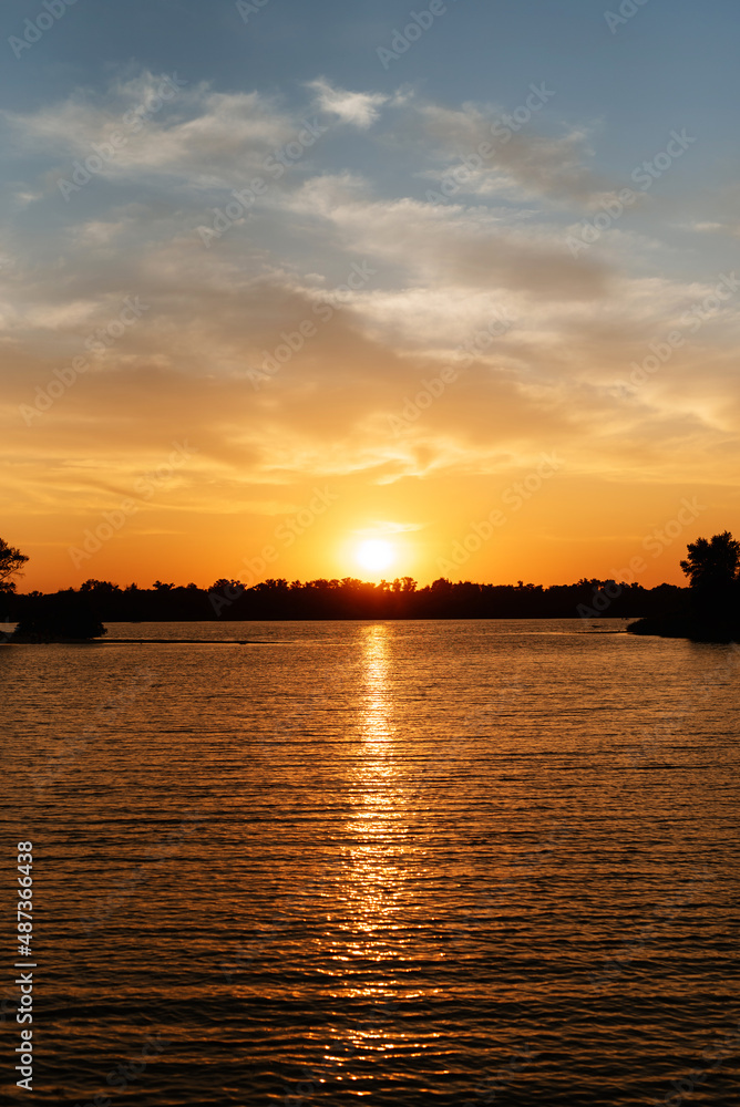 Fototapeta premium orange sunset on the river with silhouettes