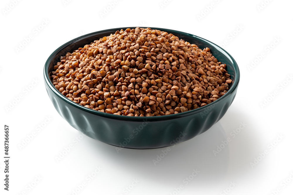 Raw wholegrain buckwheat groats in a blue bowl isolated on a white background. Roasted organic buckwheat grains for gluten free diet. Vegetarian food and cooking porridge concepts. Raw wholegrain buckwheat groats in a blue bowl isolated on a white background. Roasted organic buckwheat grains for gluten free diet. Vegetarian food and cooking porridge concepts.