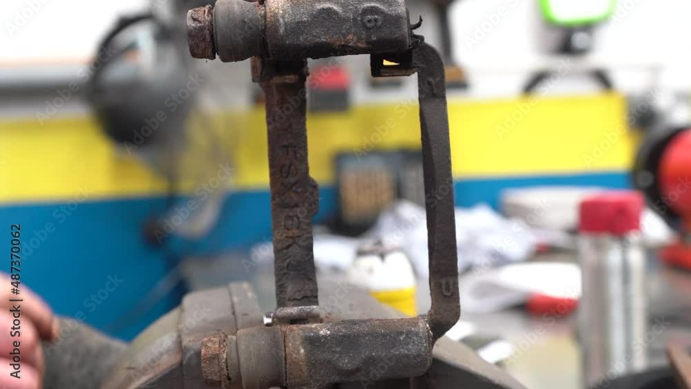 A technician lubricating a brake slider and making sure it is moving freely A technician lubricating a brake slider and making sure it is moving freely