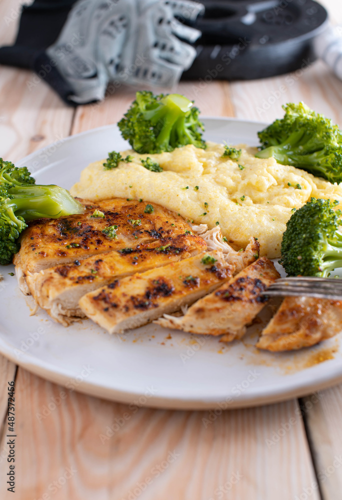 Fitness meal with pan fried chicken breast, low fat polenta and broccoli on a plate Fitness meal with pan fried chicken breast, low fat polenta and broccoli on a plate