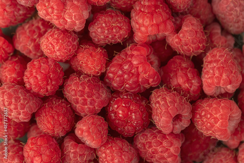 Ripe red raspberries on a plate.