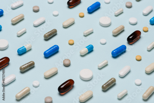 Different pills pattern on blue background. Assorted medicine drugs.