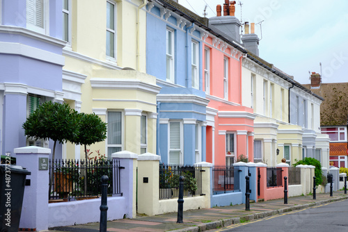 Eastbourne, United Kingdom - 26 October 2021: English street with colourful vintage terraced houses. Diminishing perspective.