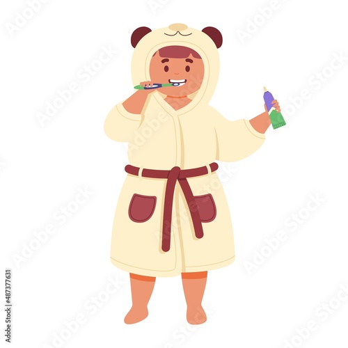 Cute child in a bathrobe brushes her teeth with a toothbrush.