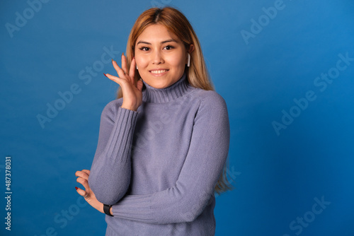 A woman of Asian appearance on a blue background