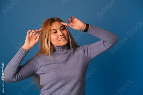 A woman of Asian appearance on a blue background