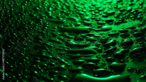 Drops and stains of water in the dark green color background selective focus