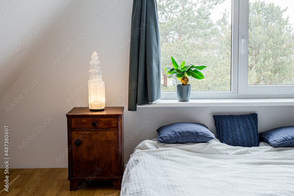 Rough big selenite crystal tower pole lamp illuminated on wooden night  stand in home bedroom, spiritual home decor accent and ambient mood light  concept. Forest seen on background. Stock-Foto | Adobe Stock