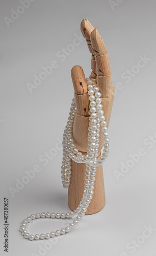 wooden hand with pearl beads isolated on white background