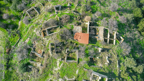 Ruins of traditional stone houses, rural depopulation in Cyprus. Aerial view directly above photo