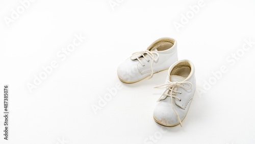 Old baby shoes on white background