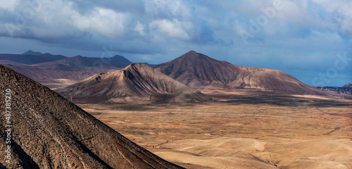 Vista panorámica de las montañas volcánicas de Caima y Tindaya desde las cima de la Montaña Roja en el Parque Natural de Corralejo, Corralejo, Fuerteventura, Islas Canarias, España