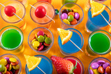 Variety of colorful green blue yellow red and white beautiful alcohol sweet shooters shots cocktail fresh beverage in small glasses. Alcoholic tropical cocktails.