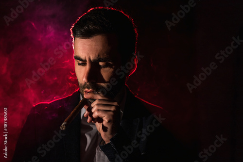 Photo of smoking man on pink background.