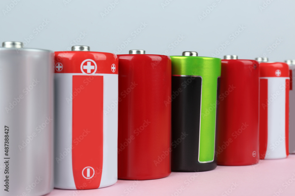 Many new D batteries on color background, closeup Many new D batteries on color background, closeup