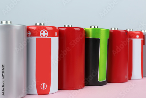 Many new D batteries on color background, closeup