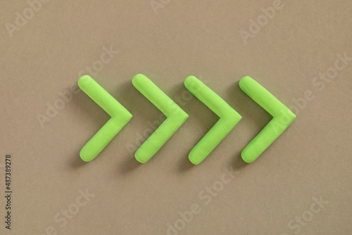 Obraz na płótnie Green arrows pointing right side. Three dimensional arrow sign showing direction on neutral background. Development concept, go green or heading target metaphor, striving for the goal, going forward. w salonie