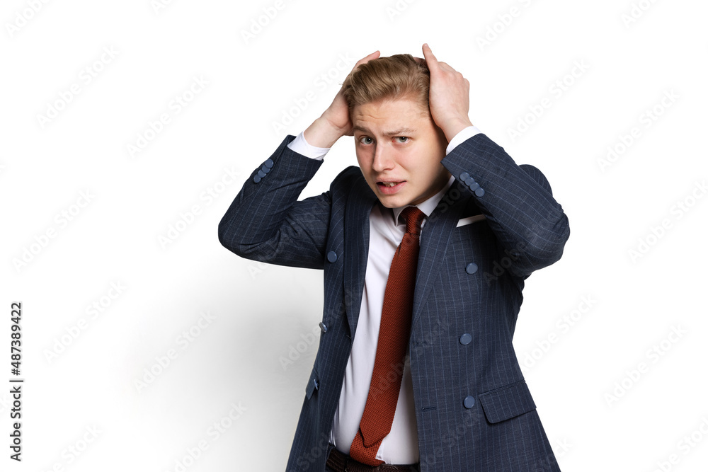 Sad young businessman, student, diplomat holding hands on head isolated on white studio background. Human emotions, facial expression concept. Sad young businessman, student, diplomat holding hands on head isolated on white studio background. Human emotions, facial expression concept.