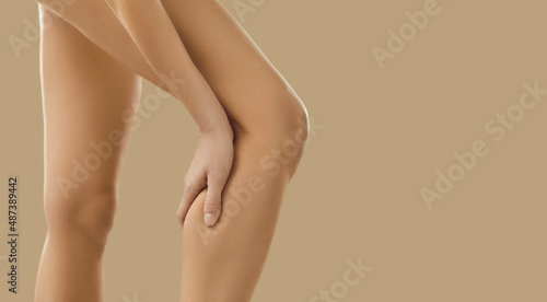Crop close up image of unhealthy naked woman having ache in leg. Pain in calf concept. Unwell female suffer from acute spasm or cramp. Torn or stretched muscle problem. Healthcare and rehabilitation. © Studio Romantic